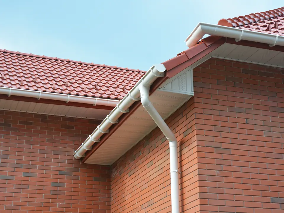 Red tiled roof with a white fascia and gutter on a brick house