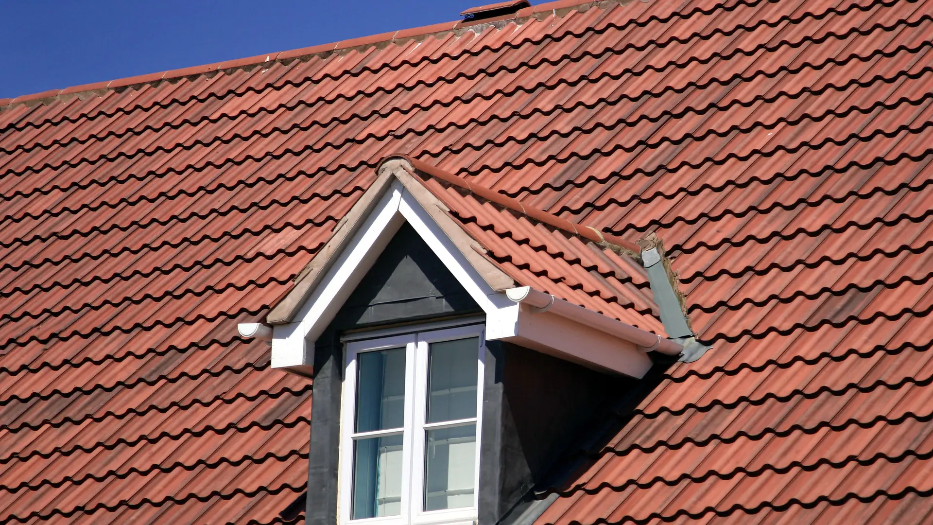 Red tiled roof with a white dormer window