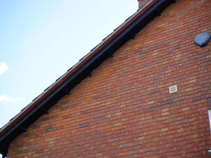 Dark bargeboard along a brick gable