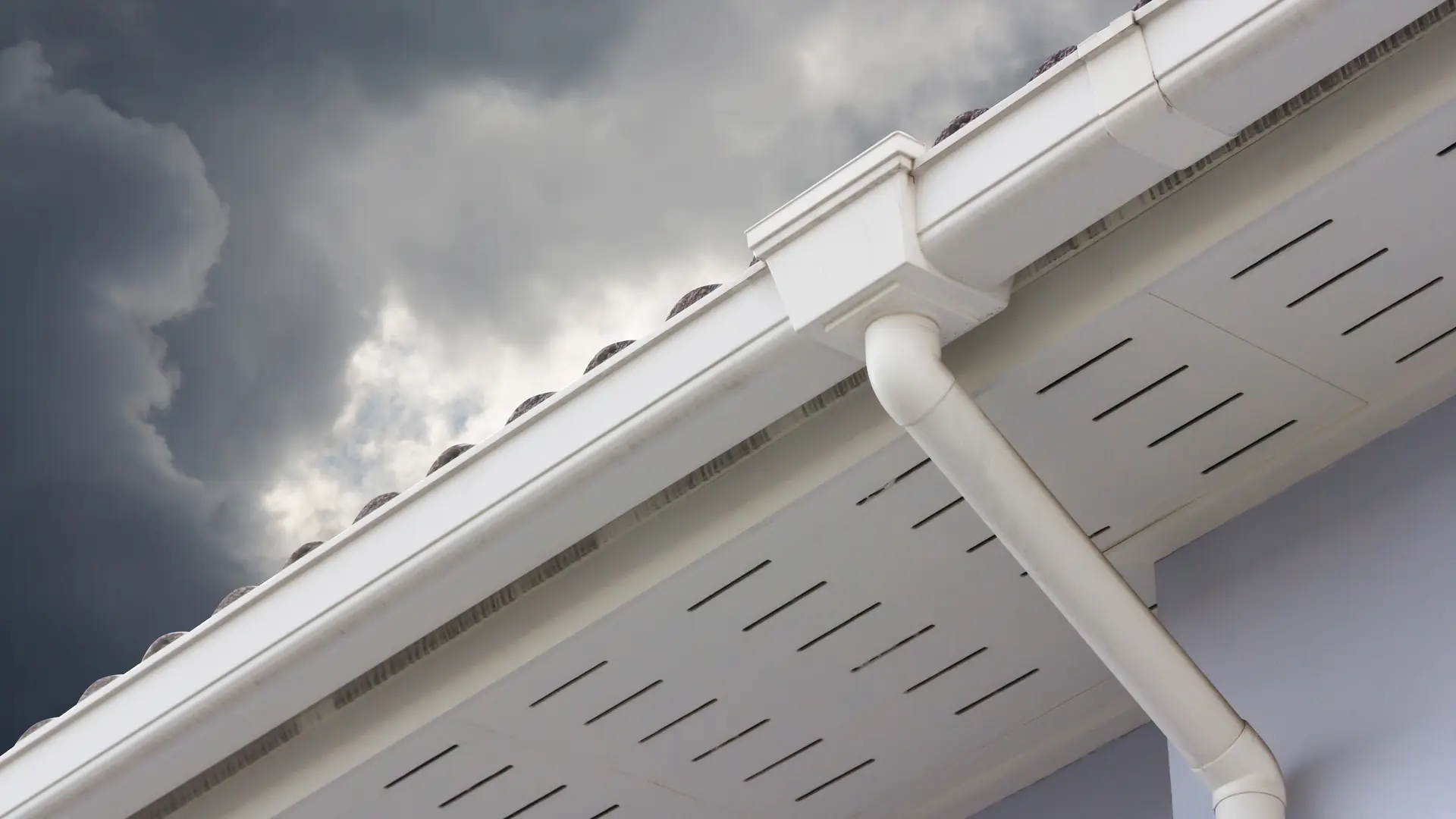 White uPVC fascia, vented soffit and gutter under a stormy sky