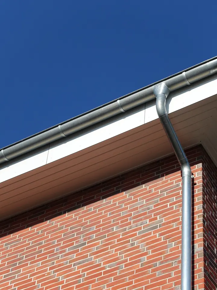 White fascia and soffit on a brick house against a blue sky