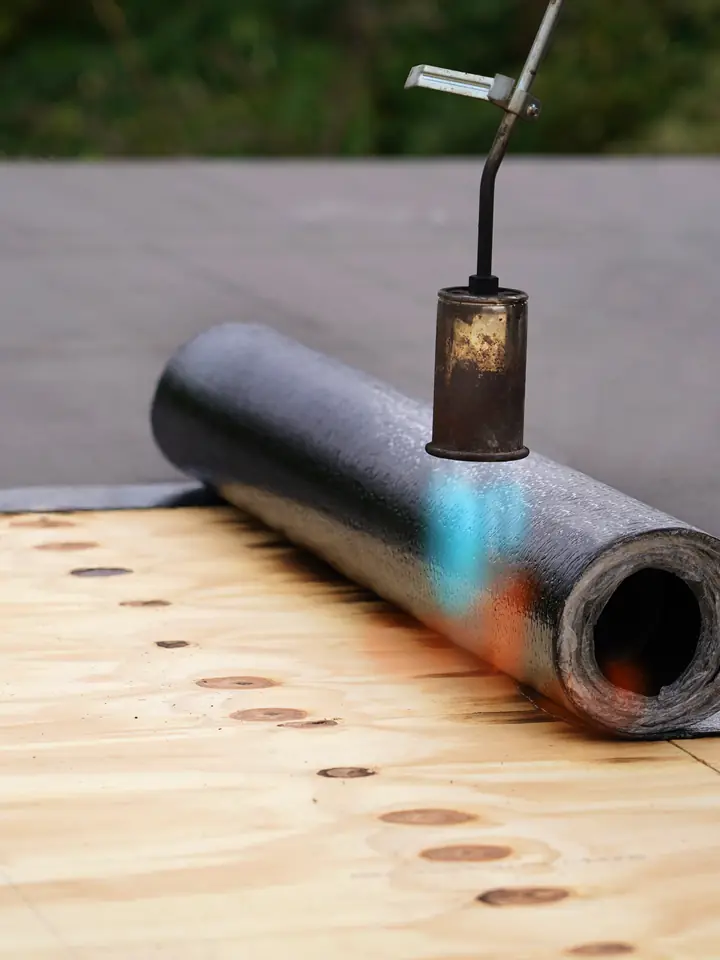 Roll of roofing felt being torched onto a timber deck