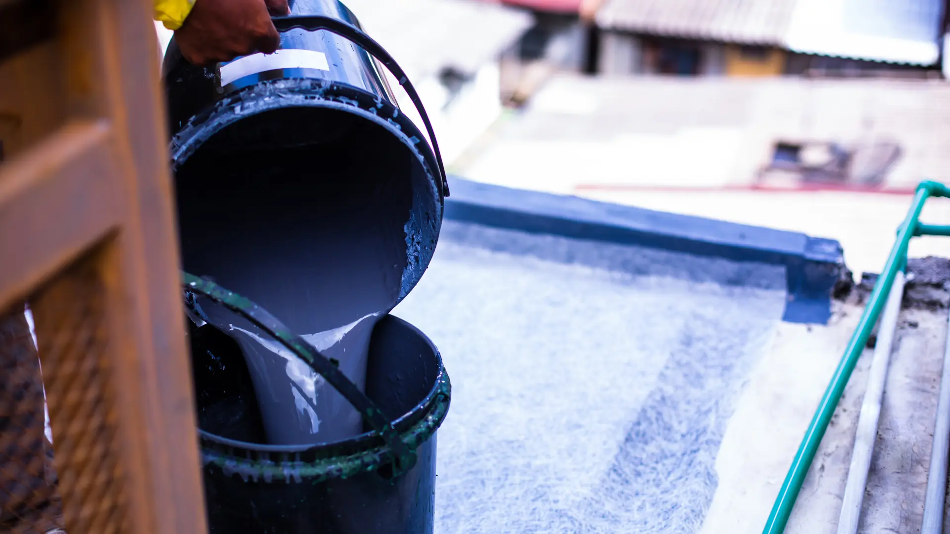 Resin topcoat being poured for a GRP fibreglass roof