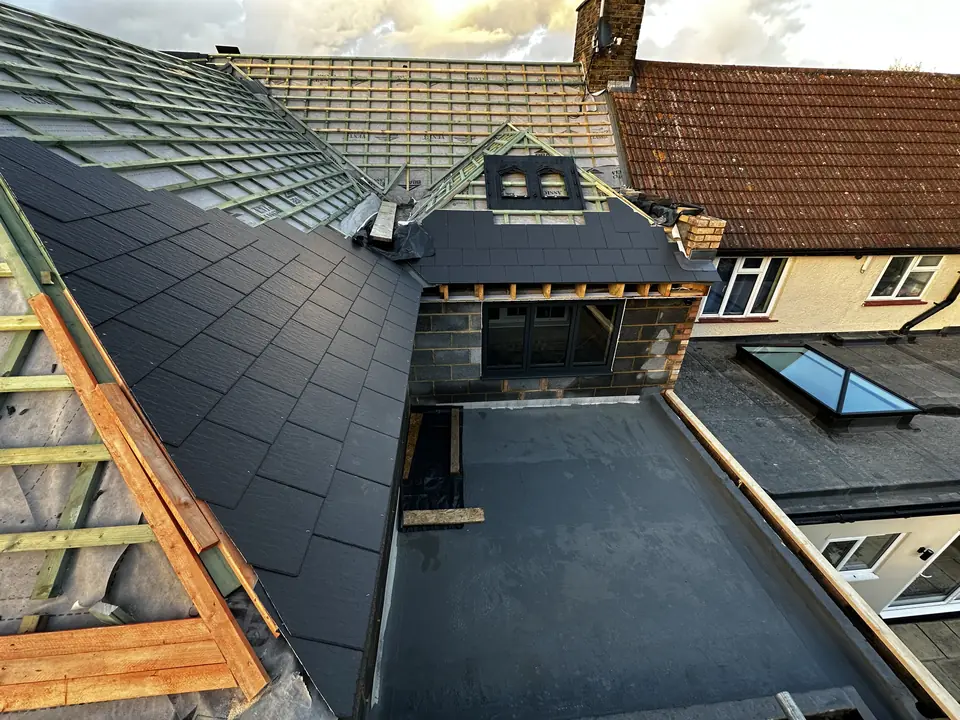 Flat roof covering laid around a roof window on a dormer