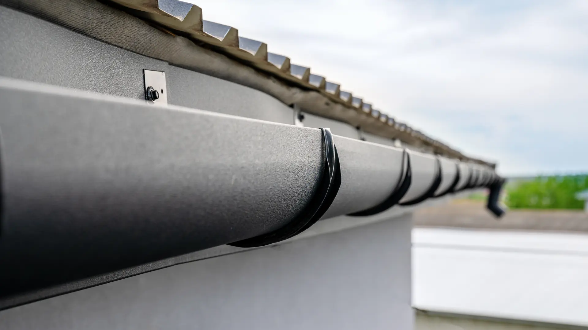 Dark grey half-round gutter on a modern house