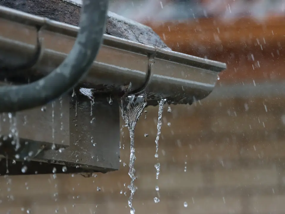 Rainwater overflowing from a blocked gutter