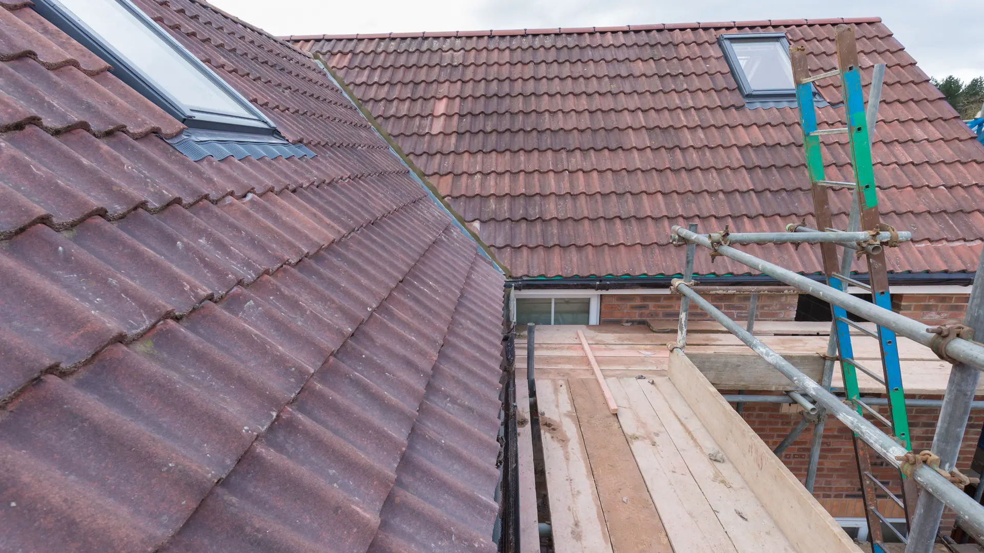 Pitched roof being re-tiled with scaffolding along the eaves