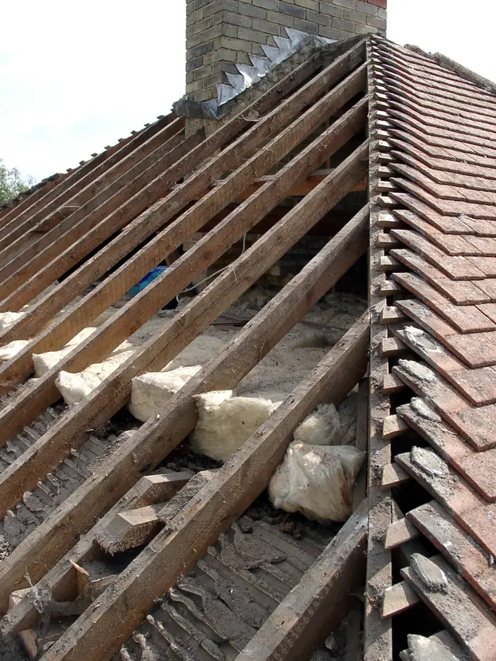 Roof stripped back to the battens beside a chimney for repair