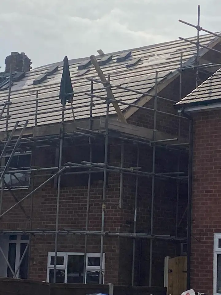 Slate roof work behind a scaffold
