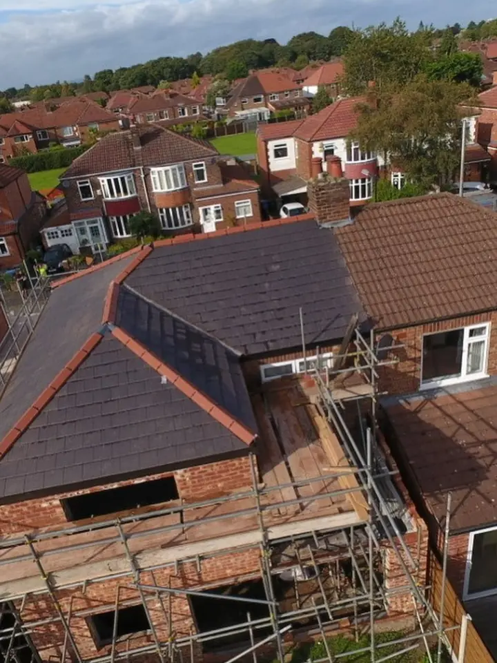 Tiled roof going on behind a full scaffold